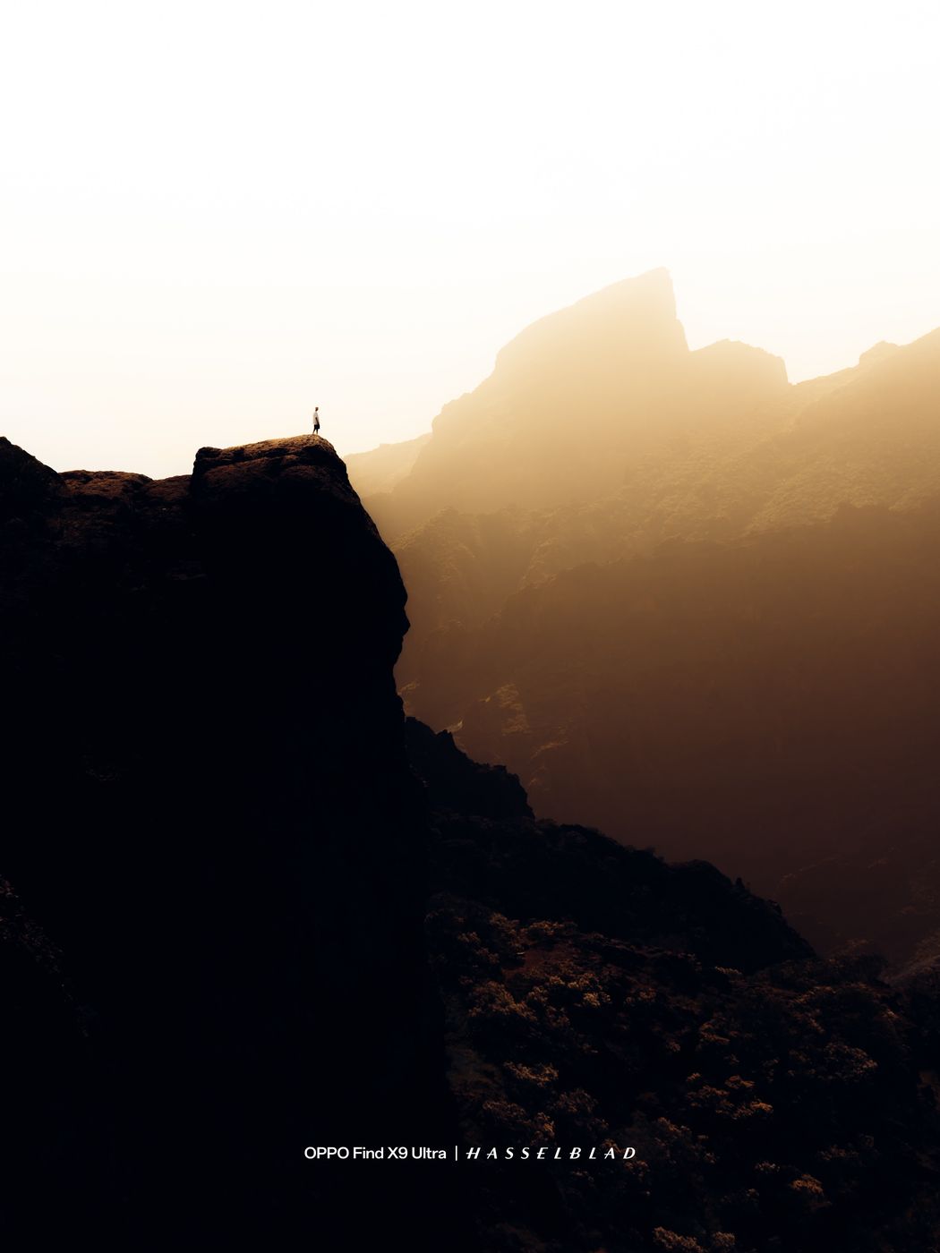 Lone figure on a ridge above a sea of haze